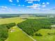 Breathtaking aerial showcasing acreage with wooded landscape and well-maintained paved road for easy access to property at 5903 Wm Griffin Rd, Monroe, NC 28112