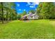 Home exterior featuring a spacious deck, lush lawn, and serene wooded backdrop at 5903 Wm Griffin Rd, Monroe, NC 28112