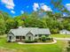 Inviting home exterior with a lush green lawn, mature trees, and charming detached garage at 5903 Wm Griffin Rd, Monroe, NC 28112