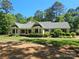 Charming single-story home featuring a well-manicured lawn, lush greenery, and a welcoming screened porch at 5903 Wm Griffin Rd, Monroe, NC 28112