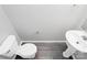 Clean half bathroom with sleek fixtures, modern flooring, and a pedestal sink at 5943 Pisgah Way, Charlotte, NC 28217