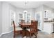 Bright breakfast nook with a wooden table, chairs, and light from the door at 5943 Pisgah Way, Charlotte, NC 28217