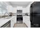 Well-lit kitchen featuring white cabinetry, stainless steel appliances, and tile backsplash at 5943 Pisgah Way, Charlotte, NC 28217