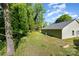 The serene backyard features a new roof and green siding home with a private wooded view at 611 Fernwood Dr, Albemarle, NC 28001