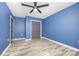 Bedroom with calming blue walls, wood-look floors, ceiling fan, and closet for ample storage at 611 Fernwood Dr, Albemarle, NC 28001