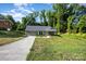 Inviting single-story home featuring a long driveway and cozy front porch at 611 Fernwood Dr, Albemarle, NC 28001