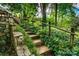 Stone steps lead to the backyard through lush greenery and mature trees at 6516 Sharon Hills Rd, Charlotte, NC 28210
