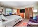 Comfortable bedroom features a calming color scheme, TV, desk area, and an inviting seating area at 6516 Sharon Hills Rd, Charlotte, NC 28210