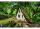 Unique A-frame house surrounded by lush greenery and trees at 6516 Sharon Hills Rd, Charlotte, NC 28210