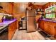 Galley style kitchen featuring wood cabinets and stainless steel refrigerator at 6516 Sharon Hills Rd, Charlotte, NC 28210