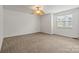 Expansive bedroom space with plush carpeting, large window, and natural light, offering versatility for decor and layout at 9047 Rosalyn Glen Rd, Cornelius, NC 28031