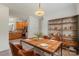 Cozy dining area adjacent to the kitchen with wooden table, shelving unit, and chandelier, perfect for Gathering meals at 9047 Rosalyn Glen Rd, Cornelius, NC 28031