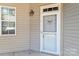 Close-up of the home's front entrance features a classic design and natural light from the adjacent window at 9047 Rosalyn Glen Rd, Cornelius, NC 28031