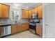 Functional kitchen with stainless steel appliances and plentiful wood cabinetry, offering ample storage and workspace at 9047 Rosalyn Glen Rd, Cornelius, NC 28031