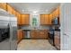 Functional kitchen with stainless steel appliances and plentiful wood cabinetry, offering ample storage and workspace at 9047 Rosalyn Glen Rd, Cornelius, NC 28031