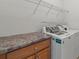 Bright laundry room with a modern washer and dryer, storage counter, and ample shelf space at 9047 Rosalyn Glen Rd, Cornelius, NC 28031