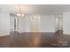 Spacious living room featuring hardwood floors, neutral walls, and a modern chandelier, creating an inviting atmosphere at 9047 Rosalyn Glen Rd, Cornelius, NC 28031