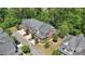 Overhead view of three brick townhomes with landscaped yards, driveways, garages, and lush green trees at 907 Ospre Ln, Fort Mill, SC 29708