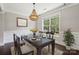 Dining room with hardwood floors, elegant chandelier, and a sunlit view of the backyard at 907 Ospre Ln, Fort Mill, SC 29708