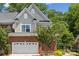 Two-story home featuring a brick facade, attached garage, and beautiful mature landscaping at 907 Ospre Ln, Fort Mill, SC 29708