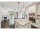 Open-concept kitchen flowing into a living area, featuring a granite island and stainless steel appliances at 907 Ospre Ln, Fort Mill, SC 29708