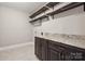 Functional laundry area includes tile floors, granite counters, and ample shelving at 907 Ospre Ln, Fort Mill, SC 29708