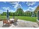 Backyard patio with seating, lush lawn, mature trees, and a playset at 9825 Ardrey Woods Dr, Charlotte, NC 28277