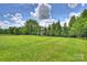 Expansive green backyard featuring mature trees and play structure at 9825 Ardrey Woods Dr, Charlotte, NC 28277