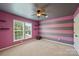 Bedroom features pink and gray striped walls, floating shelves, and a ceiling fan at 9825 Ardrey Woods Dr, Charlotte, NC 28277