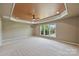 Spacious bonus room with a tray ceiling, neutral paint, and large windows at 9825 Ardrey Woods Dr, Charlotte, NC 28277