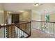 Hallway with wrought iron railing, neutral walls, and a decorative light fixture at 9825 Ardrey Woods Dr, Charlotte, NC 28277