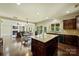 Open kitchen with granite island, view to the living room and access to outdoor spaces at 9825 Ardrey Woods Dr, Charlotte, NC 28277