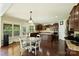 Bright kitchen featuring dark wood cabinetry, granite countertops, and an adjacent sunroom at 9825 Ardrey Woods Dr, Charlotte, NC 28277