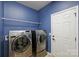 Blue laundry room with stainless steel washer, dryer, and white shelving at 9825 Ardrey Woods Dr, Charlotte, NC 28277