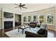 Bright living room featuring a fireplace, large windows, and leather sofas at 9825 Ardrey Woods Dr, Charlotte, NC 28277
