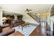 Open-concept living room featuring a staircase, fireplace, and seamless flow to the kitchen at 9825 Ardrey Woods Dr, Charlotte, NC 28277
