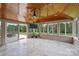 Enclosed sunroom with wood ceiling, tile flooring, and sliding door to the backyard at 9825 Ardrey Woods Dr, Charlotte, NC 28277