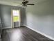Inviting bedroom with hardwood floors, ceiling fan, and a large window with soft curtains for a cozy ambiance at 106 E Gibbs St, Dallas, NC 28034