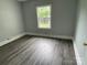 Neutral bedroom featuring vinyl plank floors, natural light, and fresh paint at 106 E Gibbs St, Dallas, NC 28034