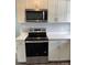 Modern kitchen with stainless steel appliances including a microwave and oven, white cabinets, and quartz countertops at 106 E Gibbs St, Dallas, NC 28034
