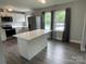 Bright kitchen with stainless steel appliances, white cabinets, a spacious island, and hardwood floors at 106 E Gibbs St, Dallas, NC 28034