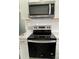 The kitchen features stainless steel appliances with a microwave and oven with white cabinets and quartz countertops at 106 E Gibbs St, Dallas, NC 28034
