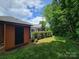 Beautiful backyard featuring an accessory shed, mature trees, and privacy hedges at 1132 Preakness Nw Ct # 24, Concord, NC 28027