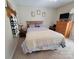 Bedroom with neutral carpet, queen size bed, dresser with TV, and charming decorative touches at 1132 Preakness Nw Ct # 24, Concord, NC 28027