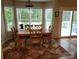 Cozy dining area with a wooden table, chairs, and ample natural light from the surrounding windows at 1132 Preakness Nw Ct # 24, Concord, NC 28027