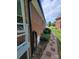 A side view of a well-maintained house with brick siding, a landscaped yard, and a stone pathway at 1132 Preakness Nw Ct # 24, Concord, NC 28027