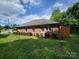 A charming, single-story brick house with lush green lawn and manicured hedges provides privacy at 1132 Preakness Nw Ct # 24, Concord, NC 28027