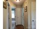 Hallway featuring hardwood floors, white trim, and doors leading to bedrooms and other living spaces at 1132 Preakness Nw Ct # 24, Concord, NC 28027