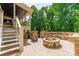 Charming backyard patio features a stone fire pit, bench seating, and stairs to upper porch at 123 Archbell Point Ln, Mooresville, NC 28117