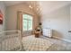 Cozy Bedroom with vaulted ceiling, plush rug, white crib, and dresser near a large window at 123 Archbell Point Ln, Mooresville, NC 28117